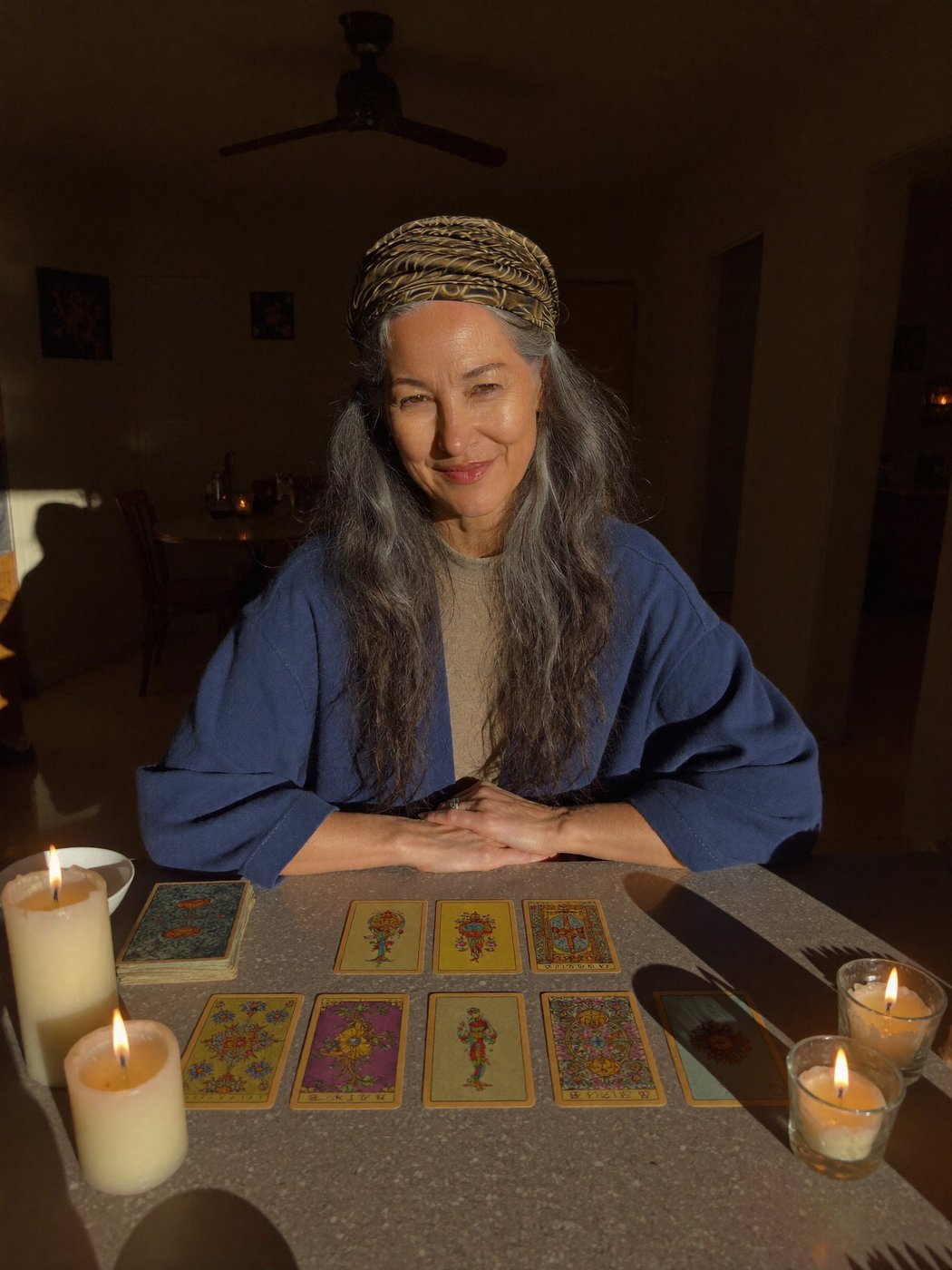Zora the seer, holding tarot cards by candlelight