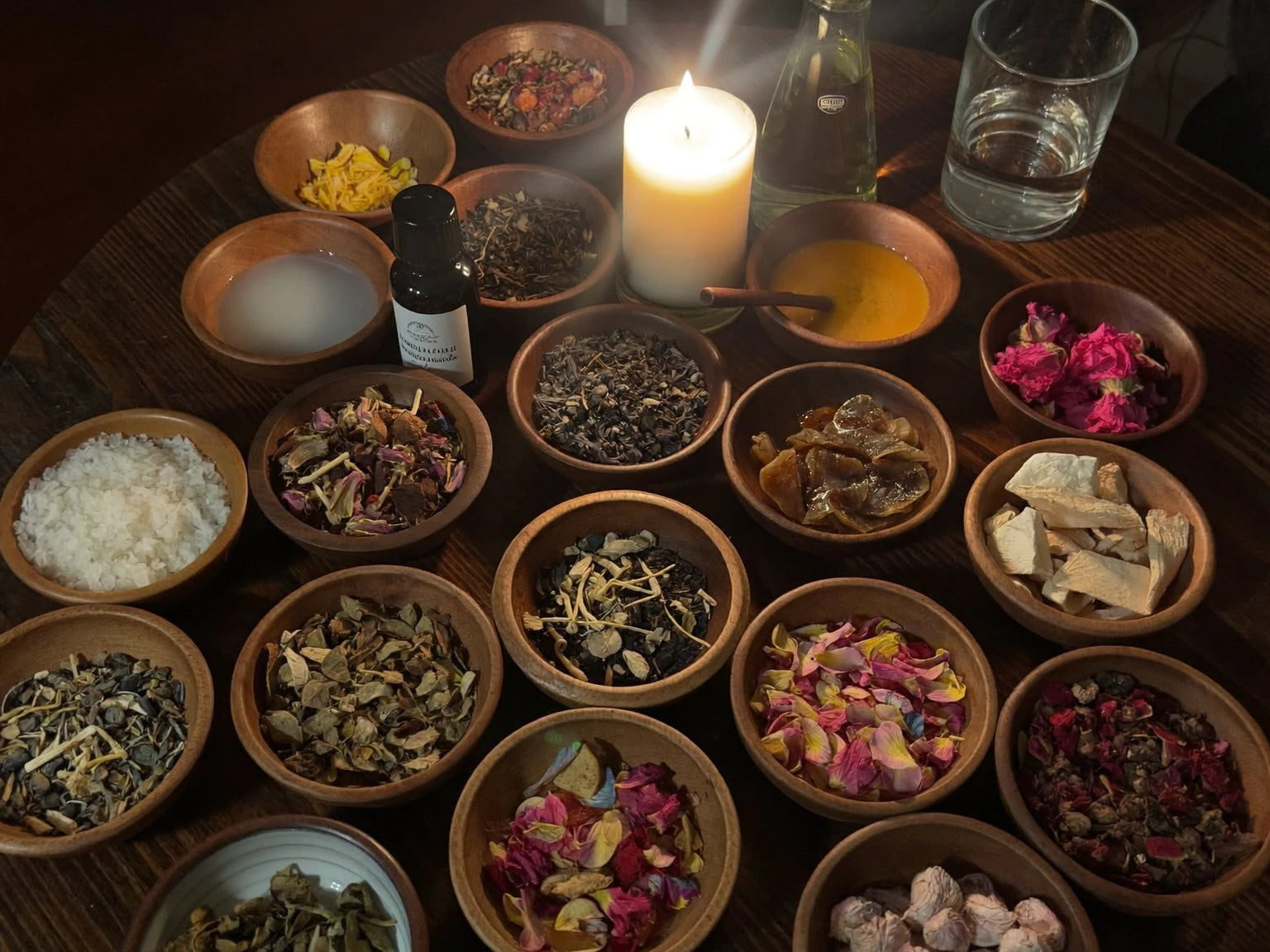 Bowls of herbs, dried roses, oils and salt laid out for a working